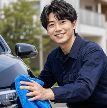 笑顔で洗車する若手スタッフ